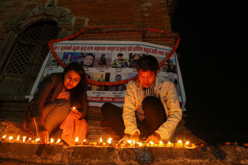 Families of Nepali citizens who enlisted as mercenaries for the Russian army and were killed in the war light lamps during a vigil ceremony in Kathmandu, Nepal, on February 24, 2024.