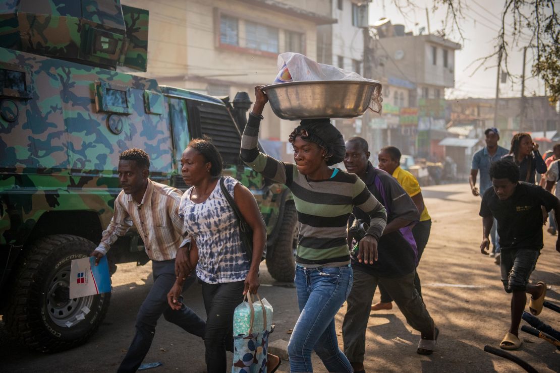 People run down a street in Port-au-Prince, Haiti, on February 29.