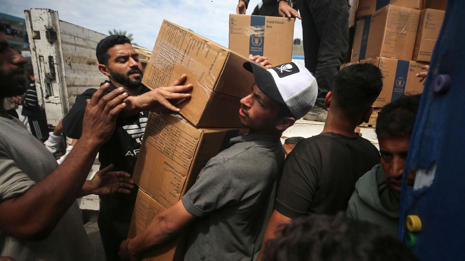 Palestinians carry boxes of aid distributed before the Eid al-Fitr holiday in the central Gazan city of Deir Al-Balah, on April 8.