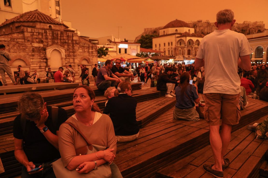 People gather outdoors as dust covers Athens, on April 23, 2024.