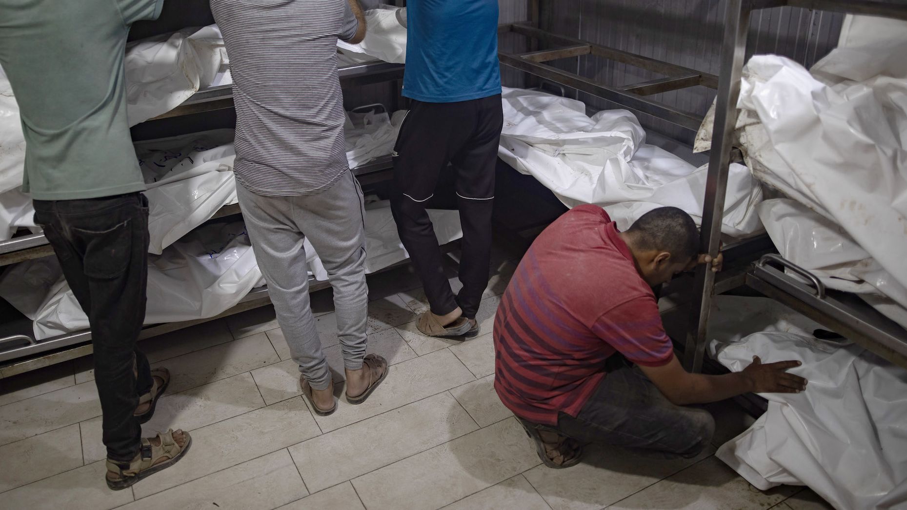 Relatives of killed Palestinians cry next to their bodies inside the morgue at Nasser Hospital in Khan Younis on July 9, 2024.