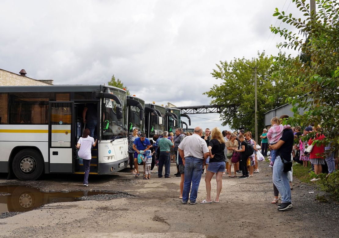 A photo provided by the government of Russia's Kursk region shows people from the border districts of the region boarding evacuation buses.