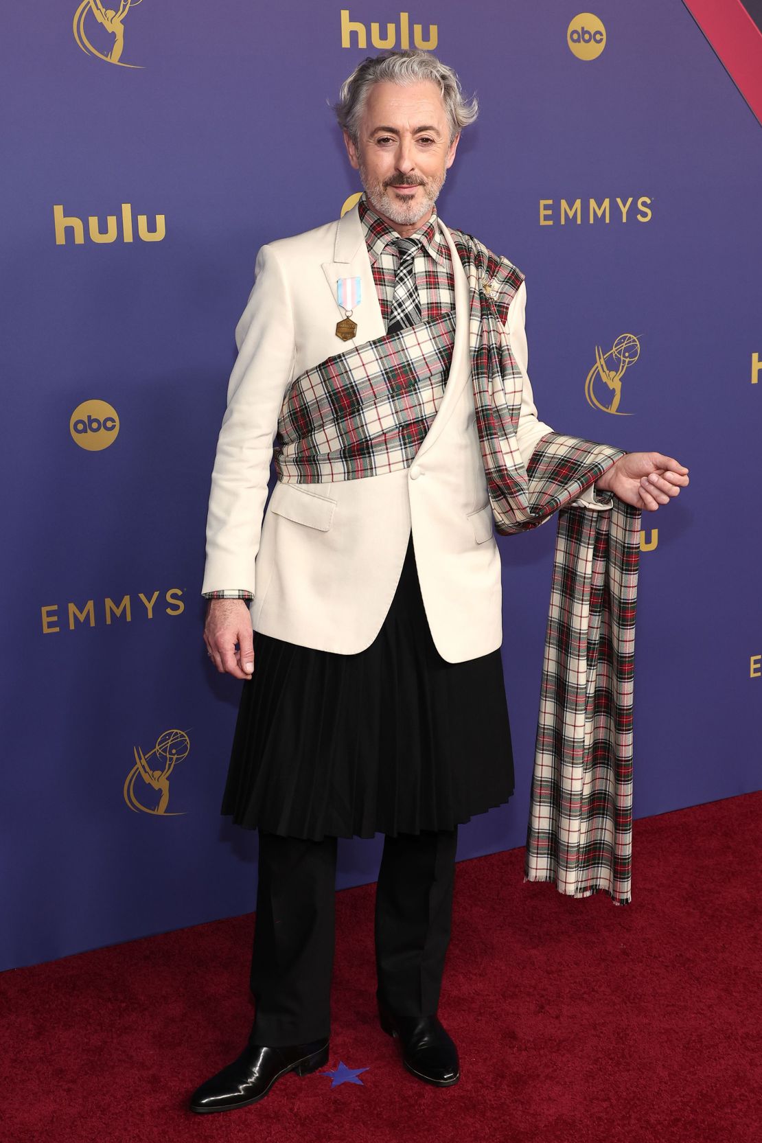 Alan Cumming wore a black wool kilt with a checked cummerbund train in Teddy Vonranson.