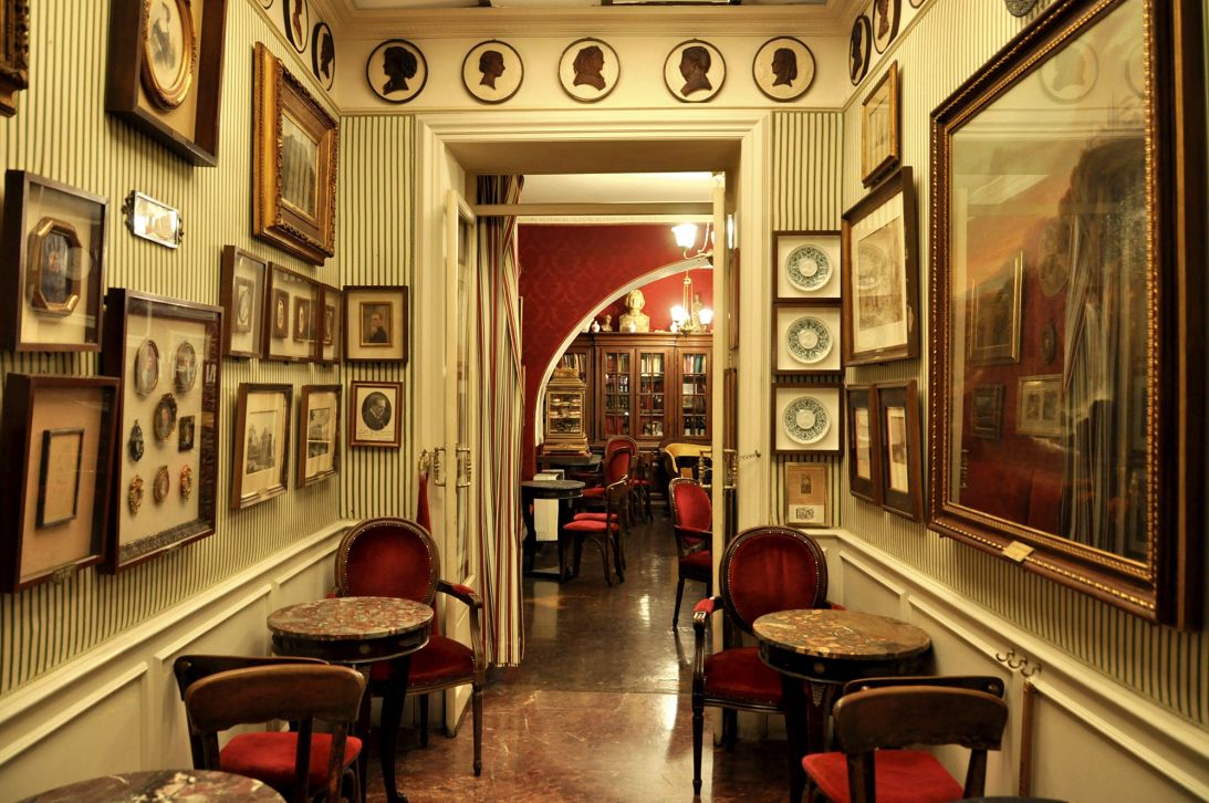 The walls of the cafe are covered with artwork and portraits of famous customers.