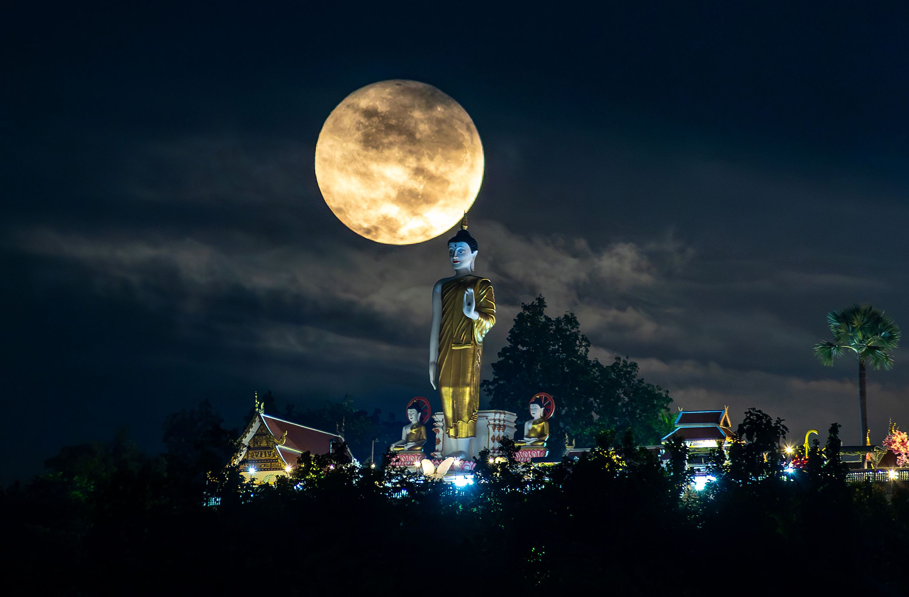 Mandatory Credit: Photo by Pongmanat Tasiri/SOPA Images/Shutterstock (14792594d) The full moon, seen on one of its closest orbits to Earth, it floats near the standing Buddha statue at Wat Phra That Doi Kham. The full moon will orbit closest to Earth, known as a 'Supermoon,' making the moon appear larger and brighter than usual. Supermoon to Illuminate the Sky in Chiang Mai, Thailand - 17 Oct 2024