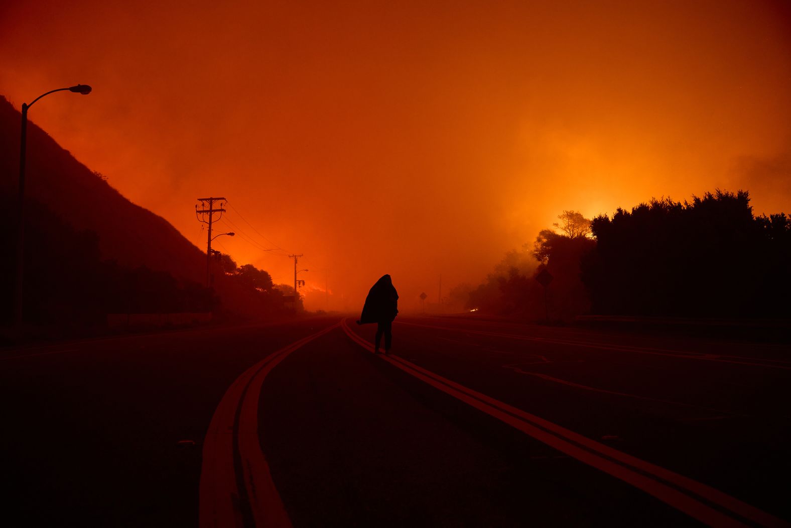 An evacuee walks down a Malibu road on Tuesday.