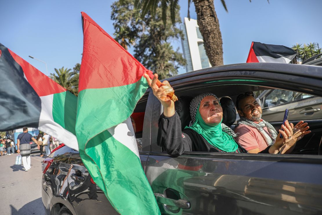 Pro-Palestinian activists wave Palestinian flags from open car windows as they depart from Tunis, Tunisia, on Monday.