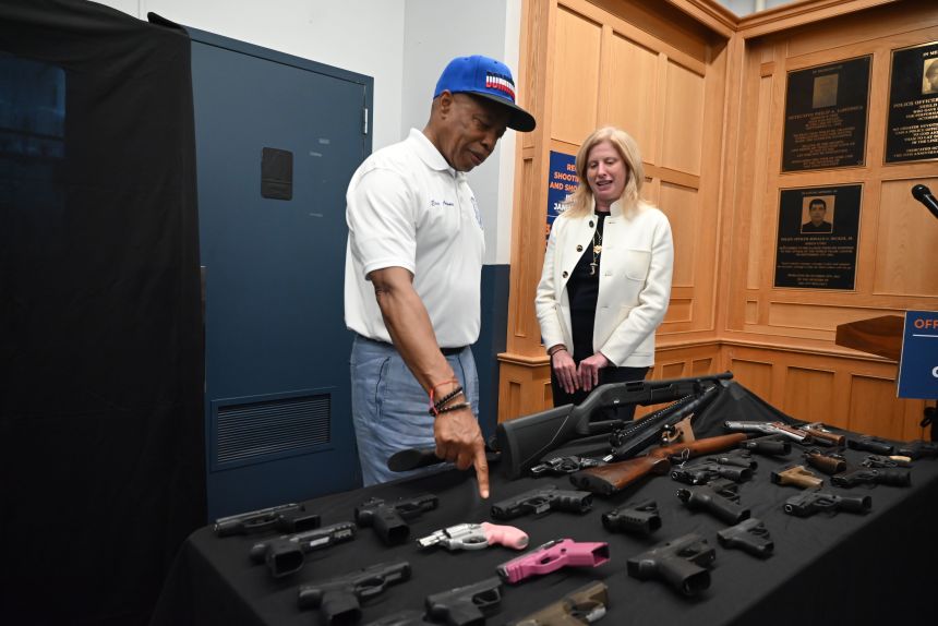 Mayor Eric Adams and New York Police Commissioner Jessica Tisch survey seized weapons before speaking with reporters in New York's Bronx borough on July 27.