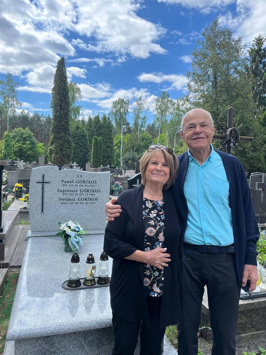 Elana Milman and her half-brother Juliusz Gorzkoś at their father's grave in Poland.