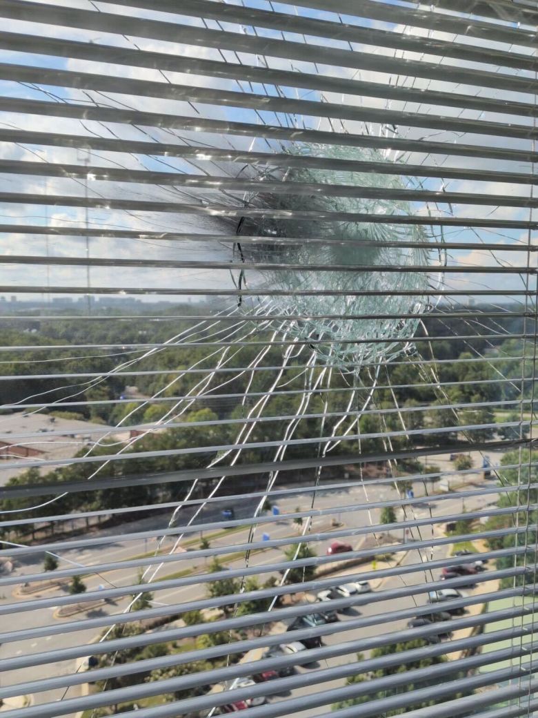 A window shattered by gunfire after shooting targeting CDC headquarters on Friday.