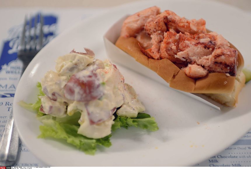 A lobster roll with a side of potato salad is served at Maine Diner in Wells, Maine.