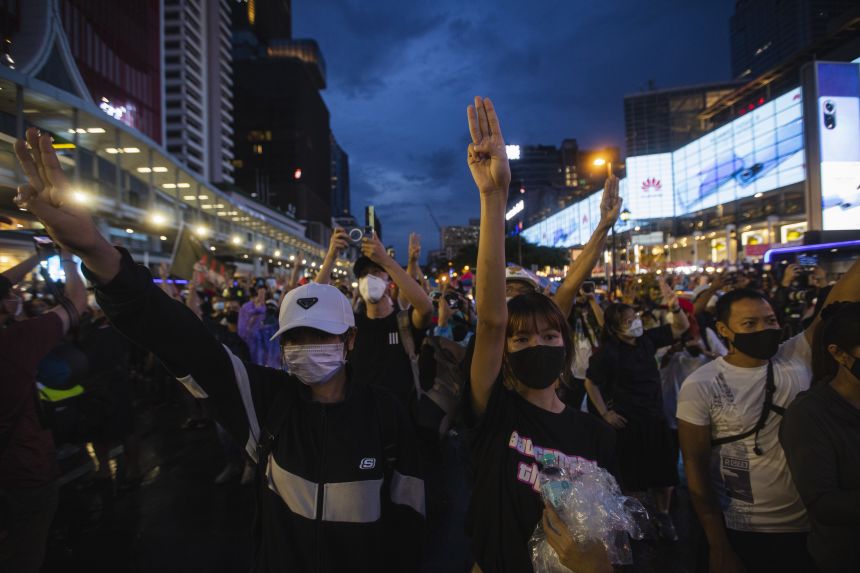 Pro-democracy protesters raise three finger salute during the demonstration demanding the abolition of the lese majeste law and monarchy reform in Bangkok, Thailand on October 31, 2021.