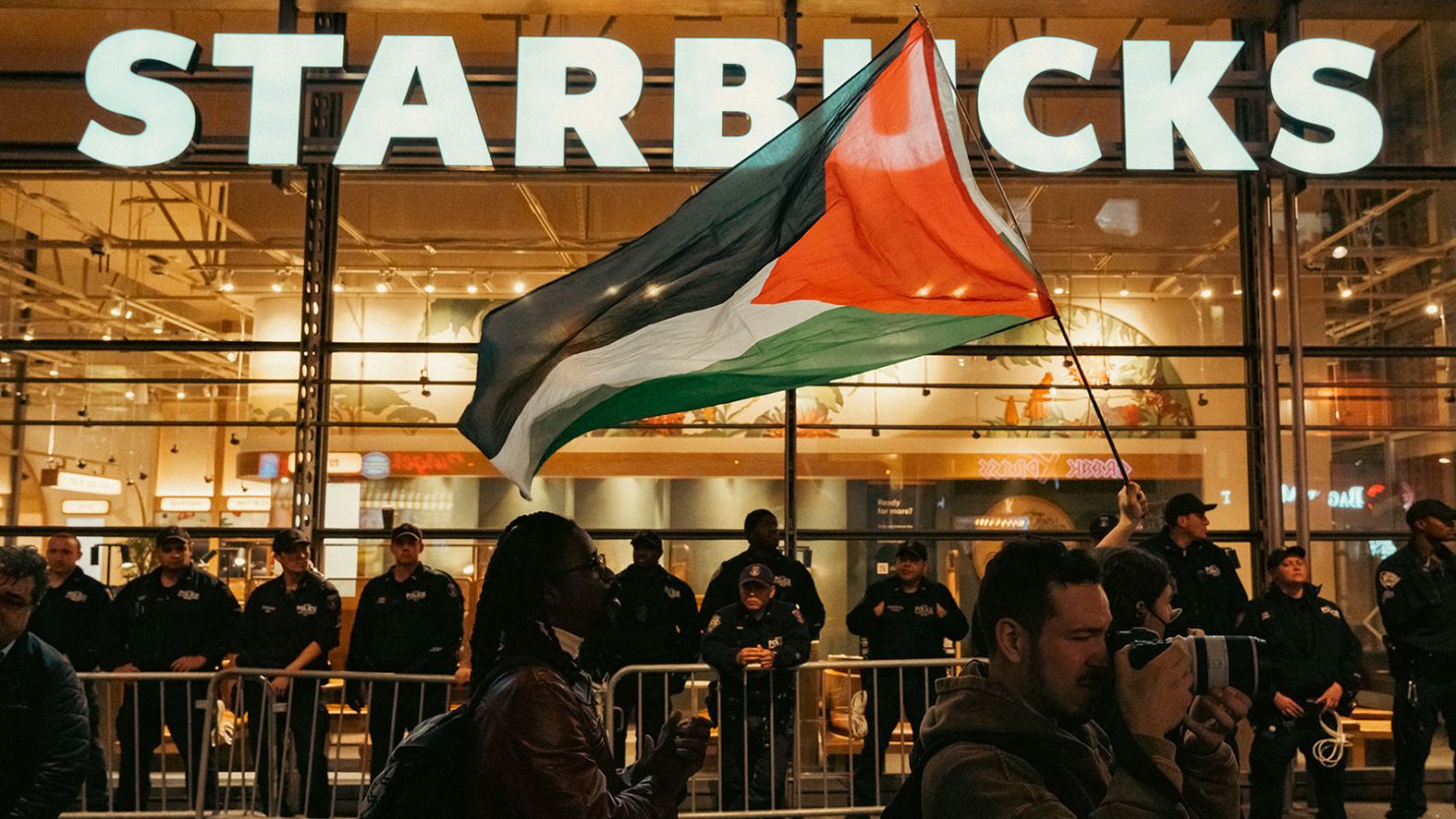 Police officers are seen barricading a Starbucks retail store from thousands of demonstrators supporting Palestine in New York City last month. Starbucks stores have seen an increase in vandalism.