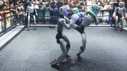 People watch two Unitree humanoids fighting in a boxing ring during a tech show in Hangzhou in east China's Zhejiang province on September 28, 2025.