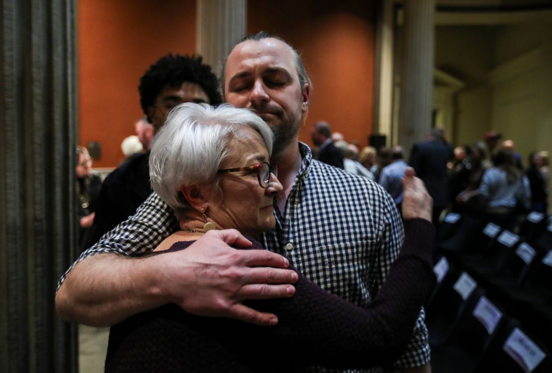 Dana Mitchell hugs her son Ross Minrath at a memorial service marking the first anniversary of the mass shooting at Old National Bank in downtown Louisville.