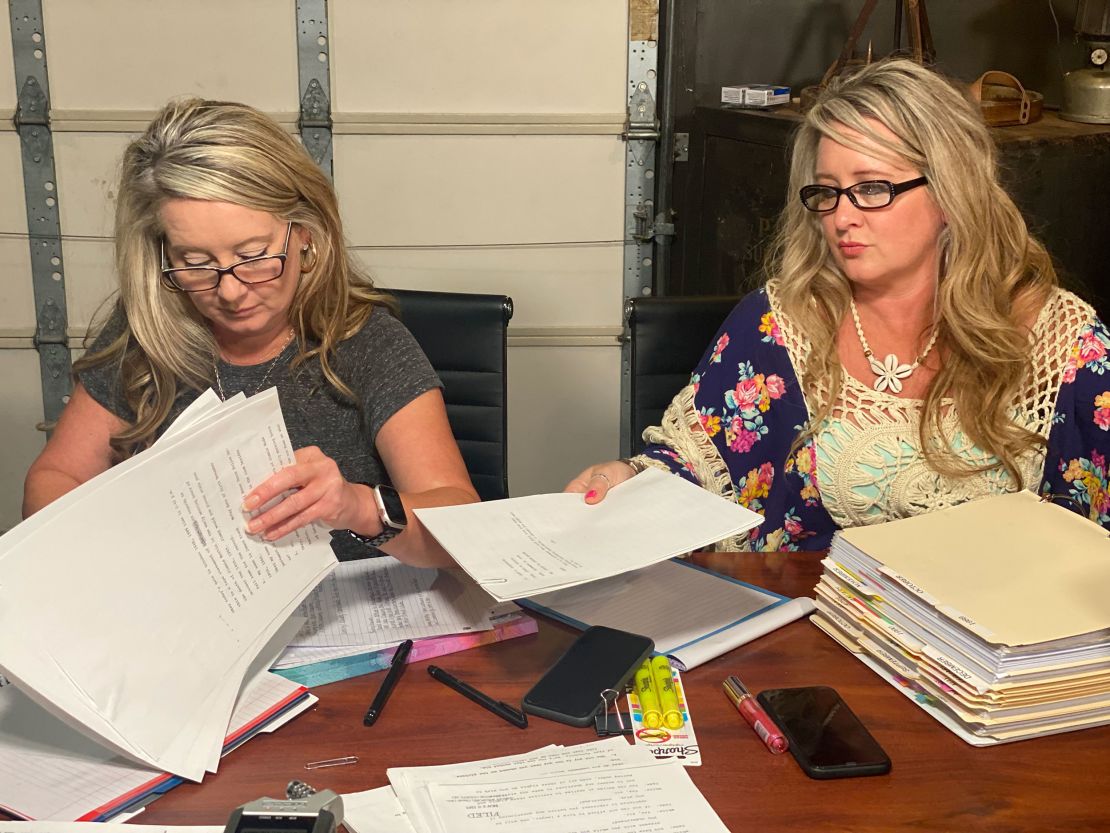 Angela Williams and Andrea Lynn, left to right, with stacks of case documents related to their dad's case.