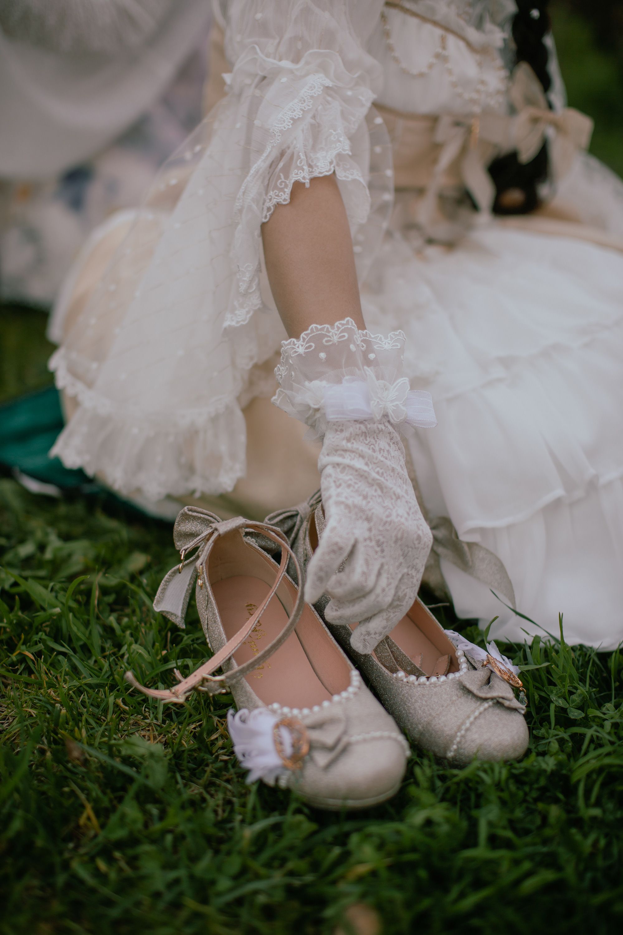 Nghi, wearing white, lace gloves, enjoys a tea party at a garden in Oakland, California, on Feb. 25, 2021. Some Lolitas use knee socks, ankle socks, or tights, together with either high heels or flat shoes with a bow.