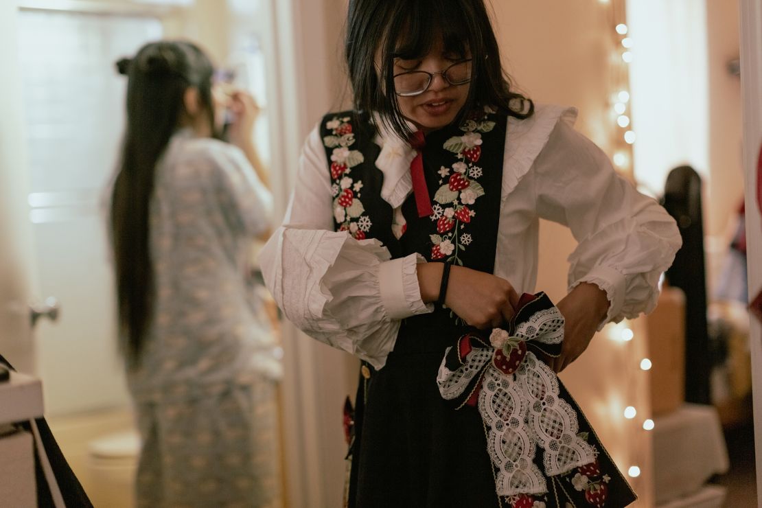 Kandace assembles her dress while Nghi puts her make-up on as they prepare for a Lolita meet-up in San Francisco, California, on Dec 3, 2022. The skirt's fullness, achieved through the use of a petticoat, is a key characteristic of Lolita fashion.
