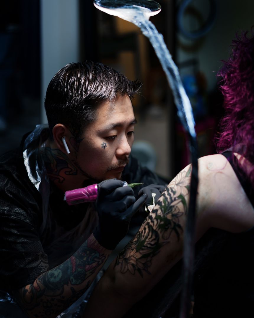 Artists at the Red Waikiki studio in Seoul, owned by Kim, also known as Sulhong (pictured), work on customers.