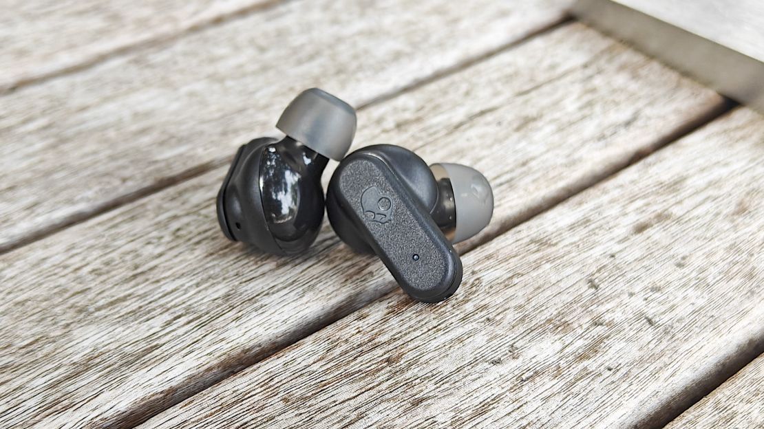 Black Skullcandy Dime Evo buds on table.