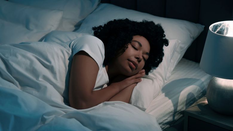 Young woman sleeping in soft bed at night