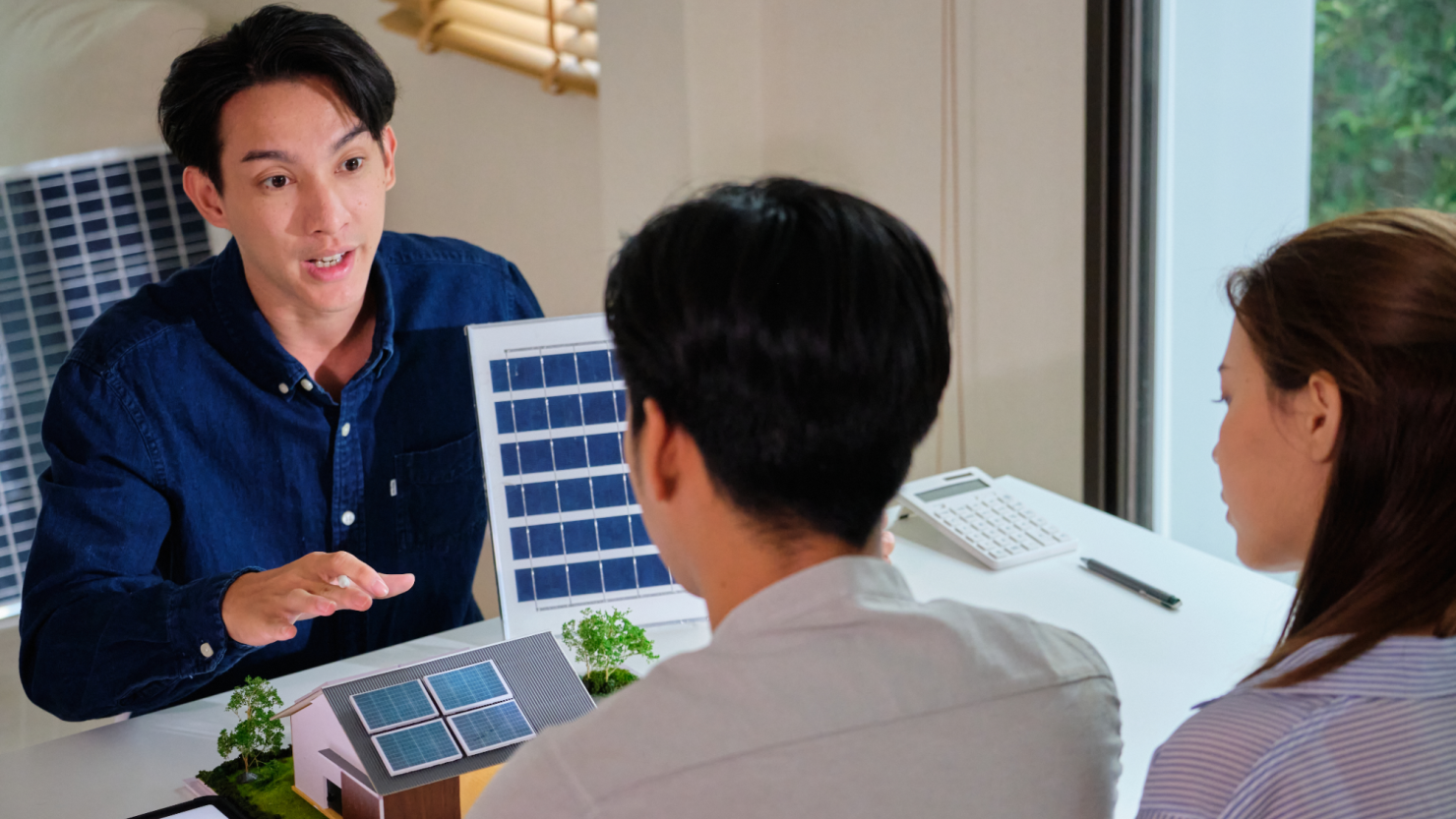 Solar energy salesman explains the benefits of solar panels to a couple.