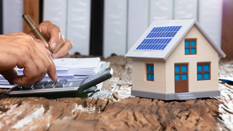 Man making calculations with a model home on a table