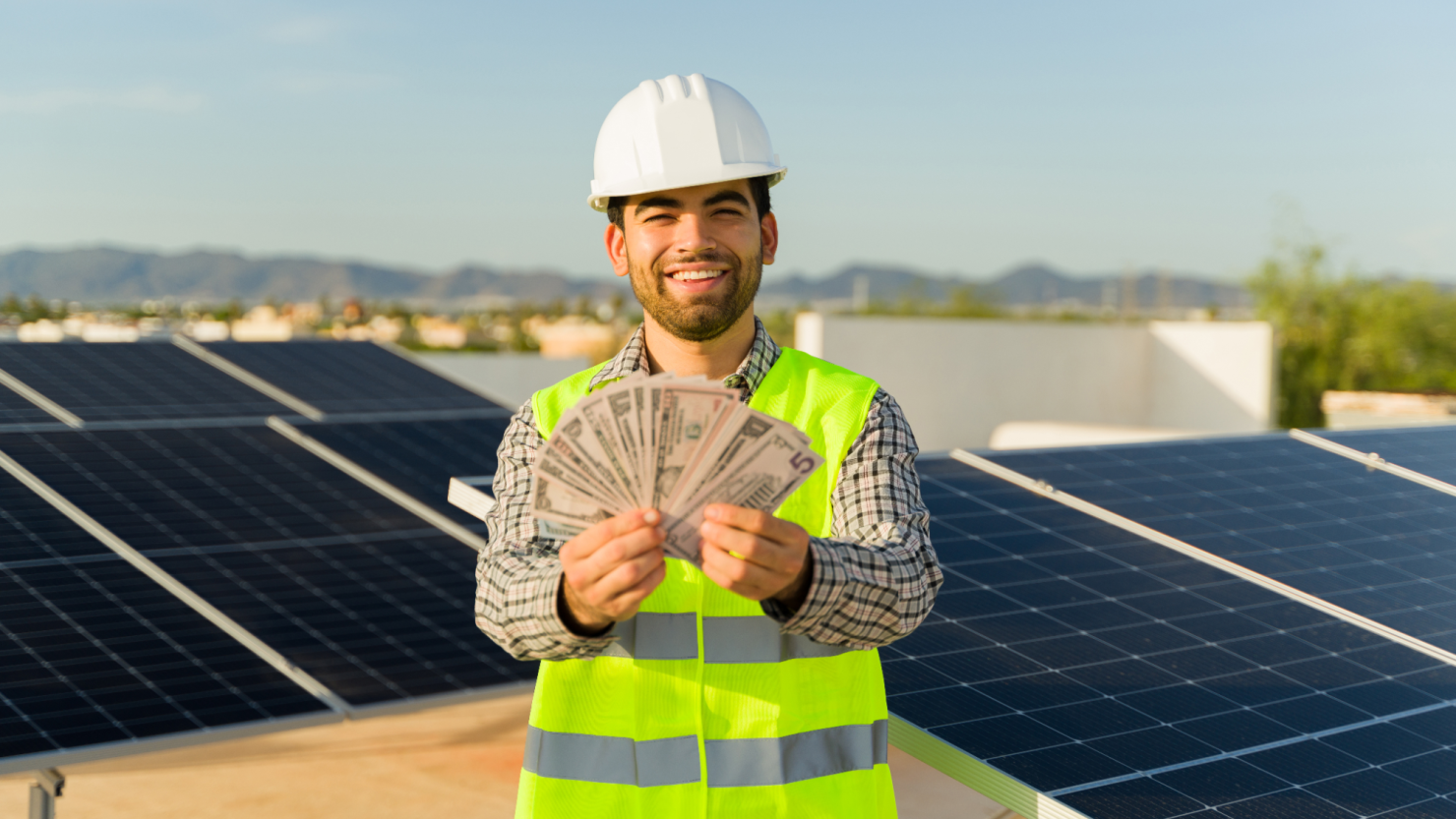 Solar installation engineer smiling with money in his hand