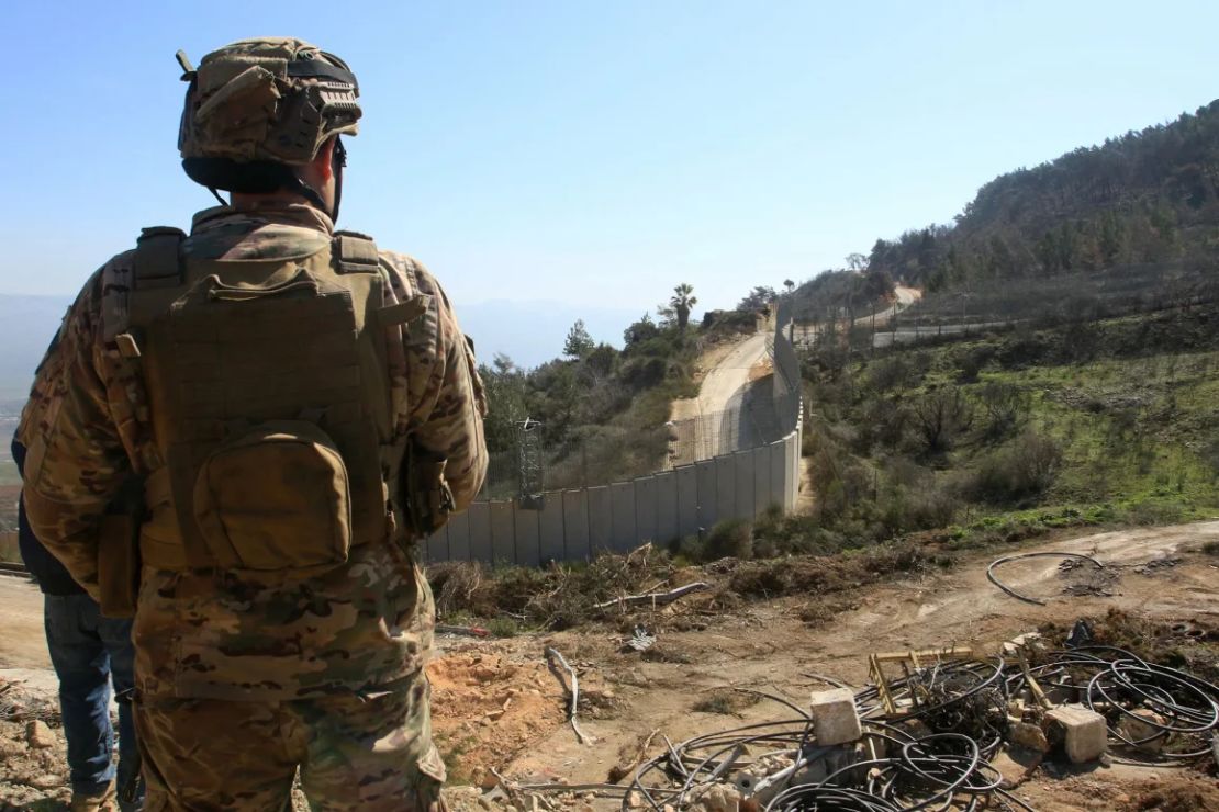Un soldado libanés observa el muro fronterizo con Israel, con un puesto militar israelí recién instalado a lo lejos el 18 de febrero.