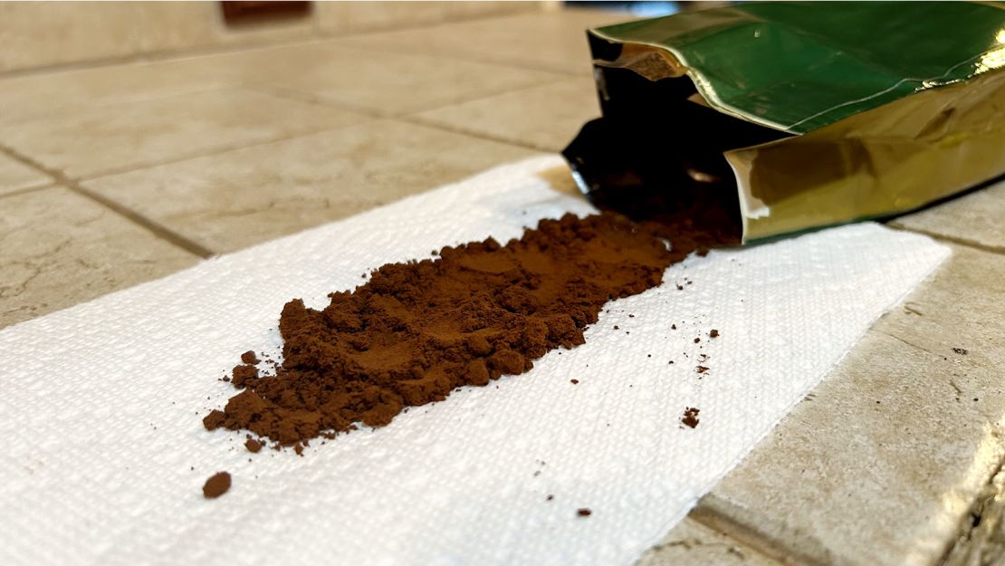 Bag of Armenian coffee open, face down on the counter with coffee grounds spilling onto napkin.