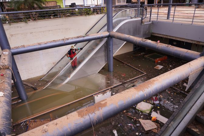 A firefighter looks at flood damage in a shopping center on the outskirts of Valencia on Monday, November 4.