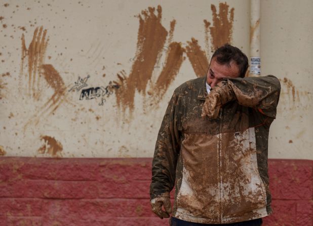 A man wipes mud off his face in Catarroja on Monday.