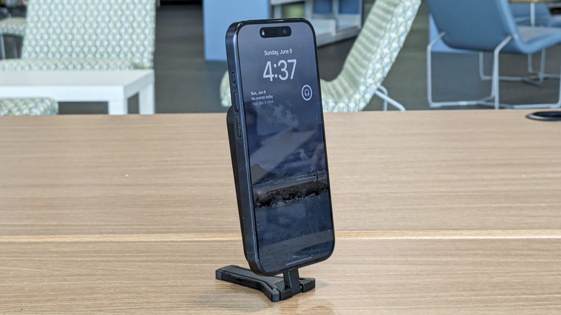 An iPhone docked in the Spigen MagFit+ Tripod Stand, whose legs aren't extended