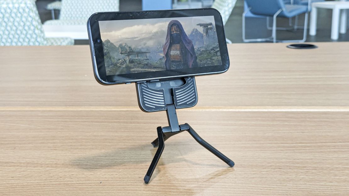 An iPhone mounted horizontally on the Spigen MagFit+ Tripod Stand plays a scene from the Star Wars: Acolyte series.