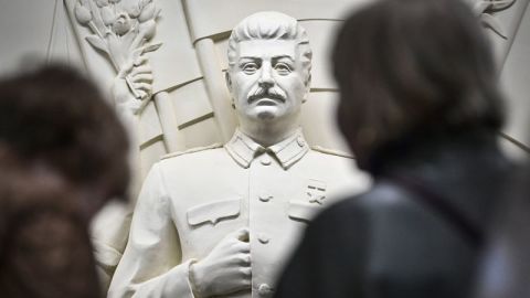 Los pasajeros se detienen frente al alto relieve recién inaugurado que representa al dictador soviético Joseph Stalin en un pasillo de la estación de metro Taganskaya de Moscú el 15 de mayo de 2025.