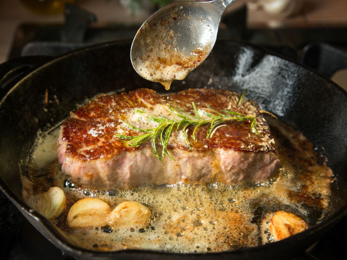 steak-cooking-in-cast-iron-skillet-with-butter-and-herbs.jpeg