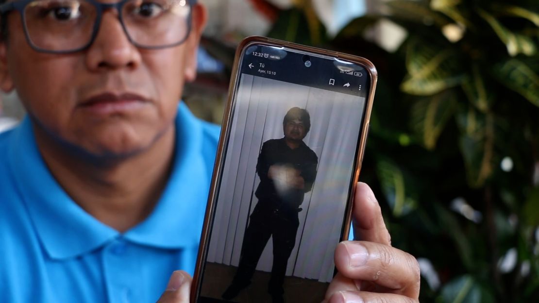 Wenceslao Contreras Ortiz holds a picture of his nephew Alejandro Hernandez Fuentes on his phone.