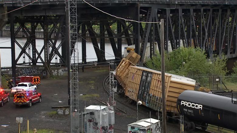 A derailed train is seen leaning against a bridge in Portland, Oregon, on April 29, 2024.
