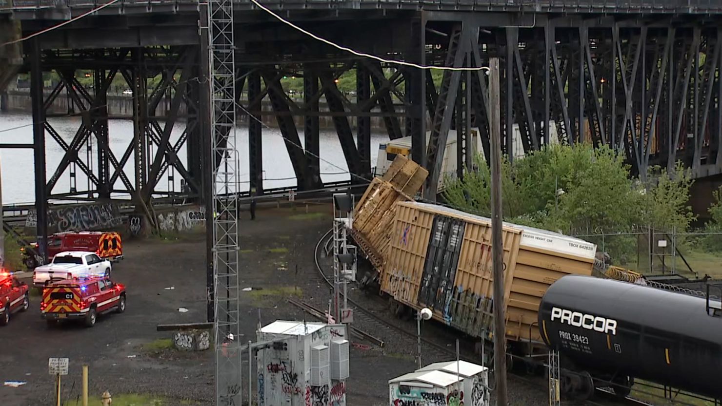 A derailed train is seen leaning against a bridge Monday in Portland, Oregon.