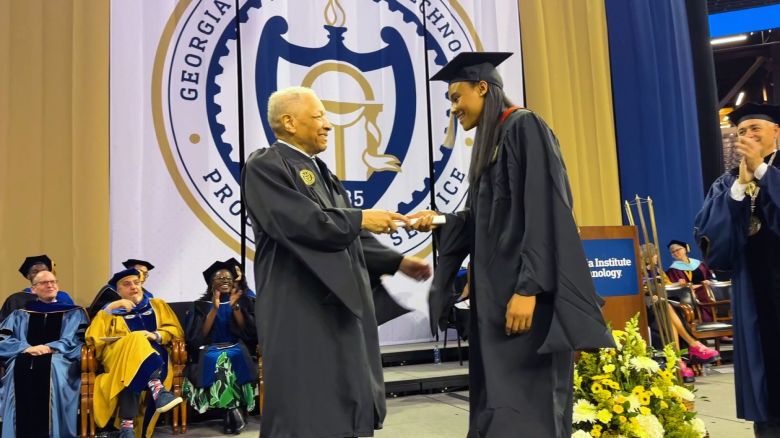 Ronald Yancey, Georgia Tech's first Black student to graduate, presents his granddaughter Deanna her diploma at her commencement ceremony on Friday, May 3, 2024.