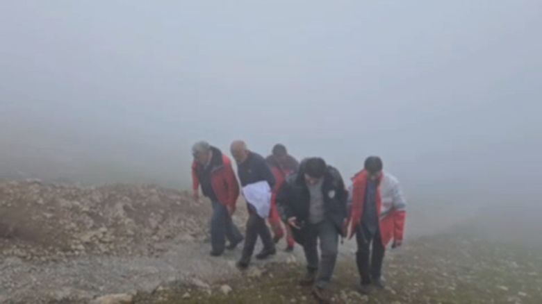 A screen grab from video released by Mehr News Agency via Telegram shows a rescue team arriving at the site of a helicopter crash in Iran on May 19.