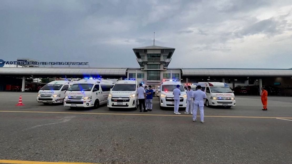 Emergency personnel are seen at a Bangkok airport following a Singapore Airlines plane making an emergency landing due to turbulence.