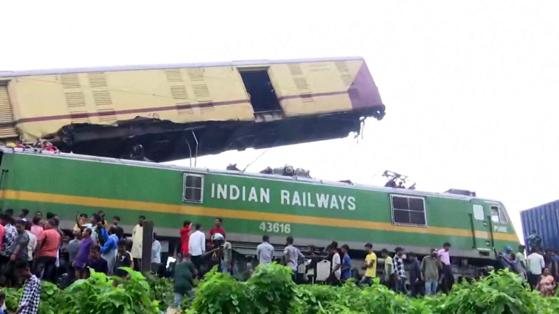 People gather around the wreckage of a train after a collision in West Bengal, India on June 17, 2024.