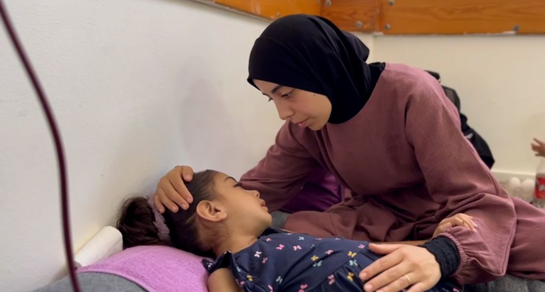 Umm Ubaida comforts her daughter, Yasmin, aged 5, in Nasser Hospital, on Tuesday.