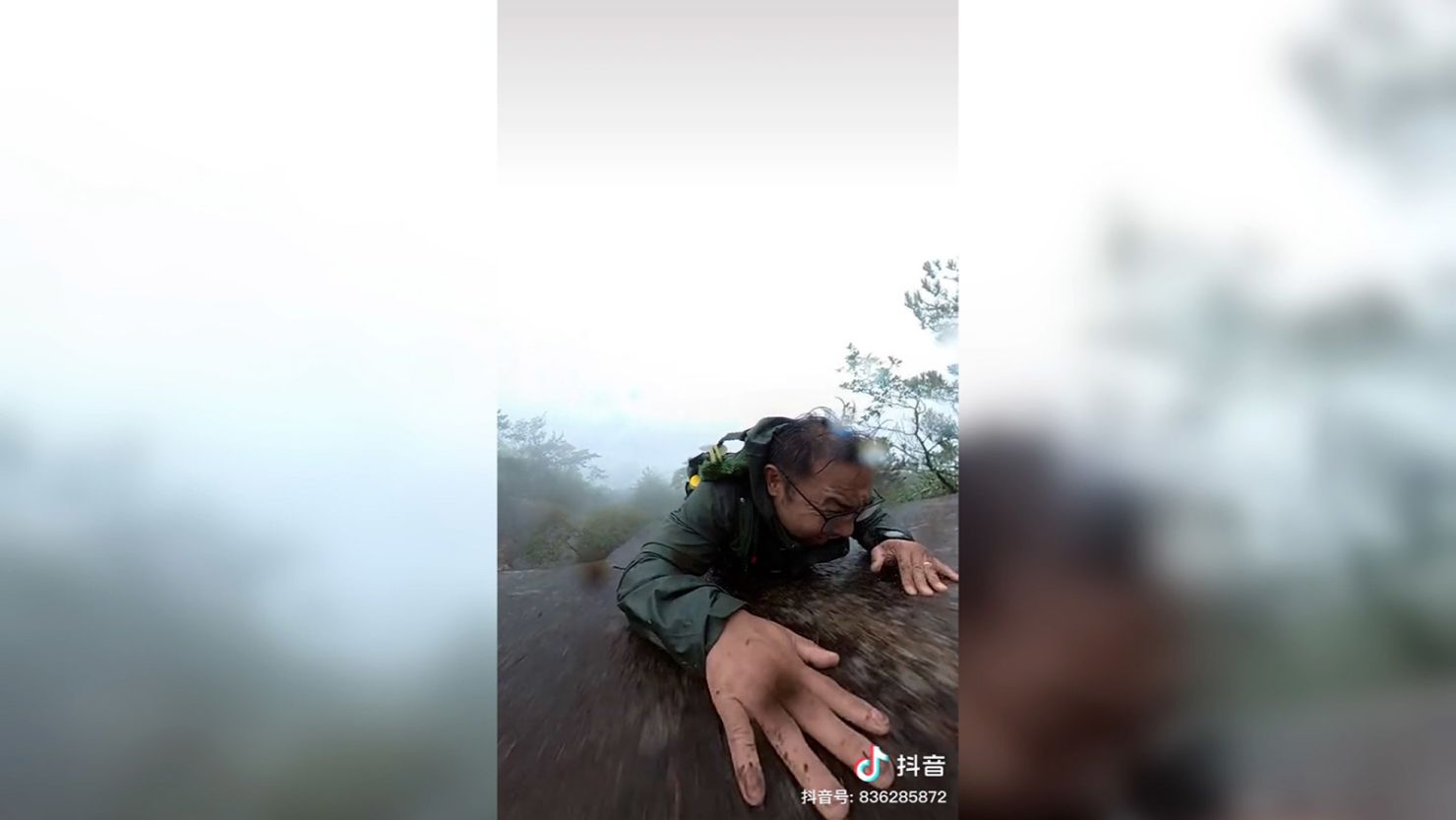 This screengrab from a video shows a man who slipped and fell down a steep rock face in the mountains of China’s Anhui province. The man, who survived the slide, told state media that a tree broke his fall just in time to prevent him from going off a cliff.