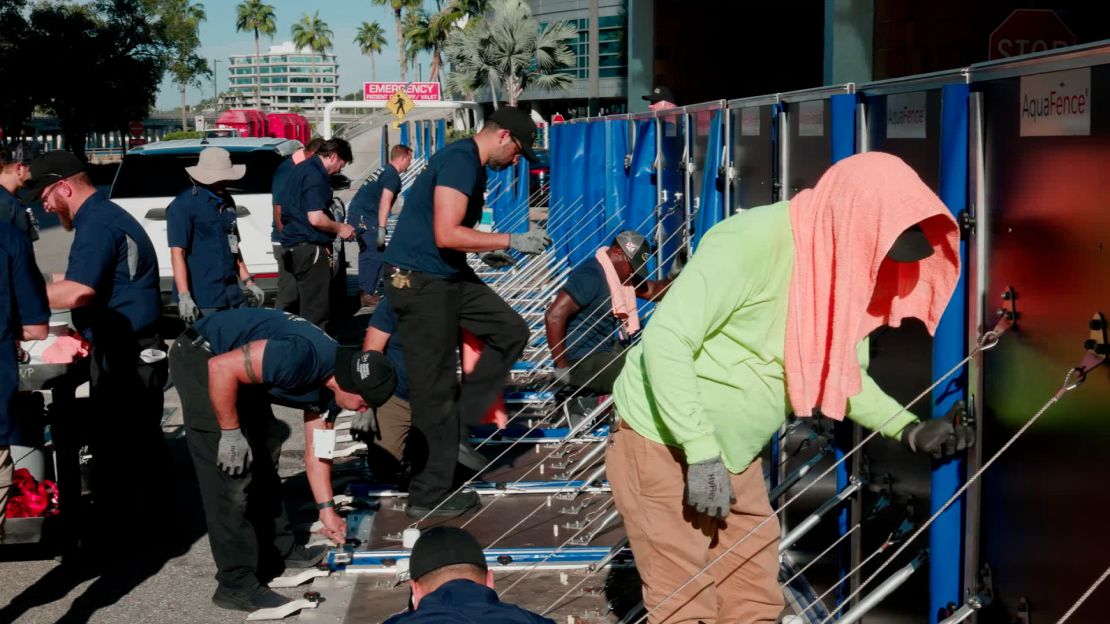 Medewerkers van het faciliteitenteam van het Tampa General Hospital installeren op dinsdag 24 september AquaFence-panelen op het ziekenhuisterrein.