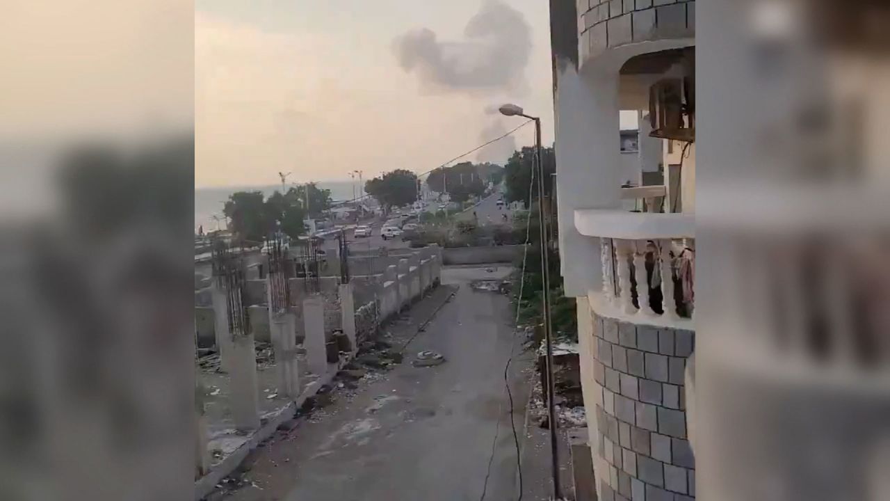 A still from a social media video geolocated by CNN shows billowing grey smoke in northern Hodeidah, a Houthi-controlled port city in western Yemen, on Friday. The footage was captured from a vantage point along the Red Sea.