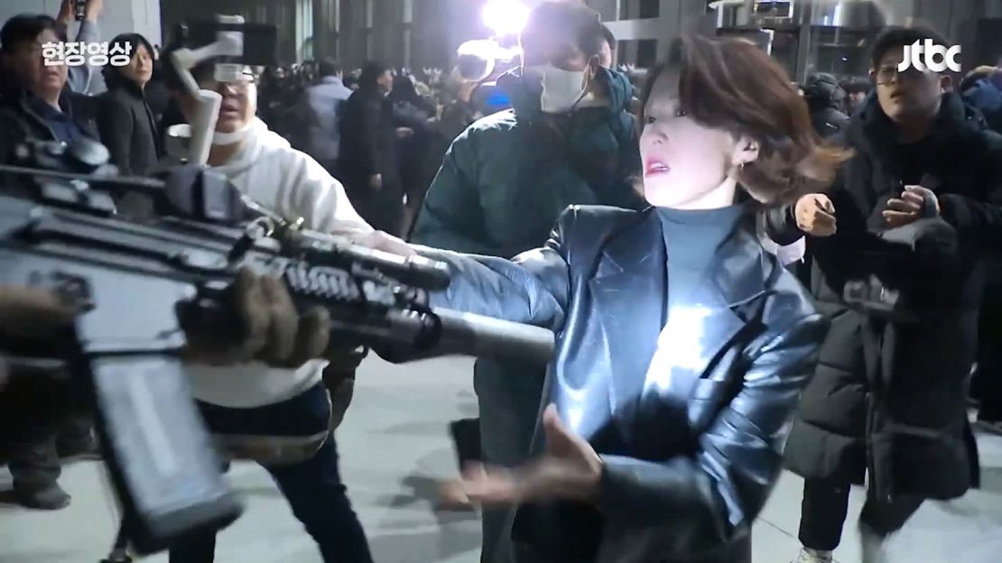 This screengrab taken from a video shows journalist-turned-politician An Gwi-ryeong grappling with and grabbing a soldier’s rifle during a protest outside of the National Assembly in Seoul, South Korea, on December 4, 2024.