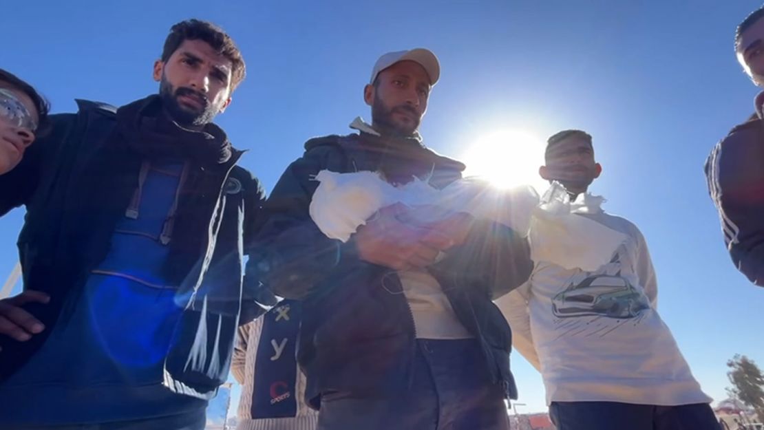 Mahmoud Al-Fasih holds the body of his three-week-old daughter Sela before laying her to rest.