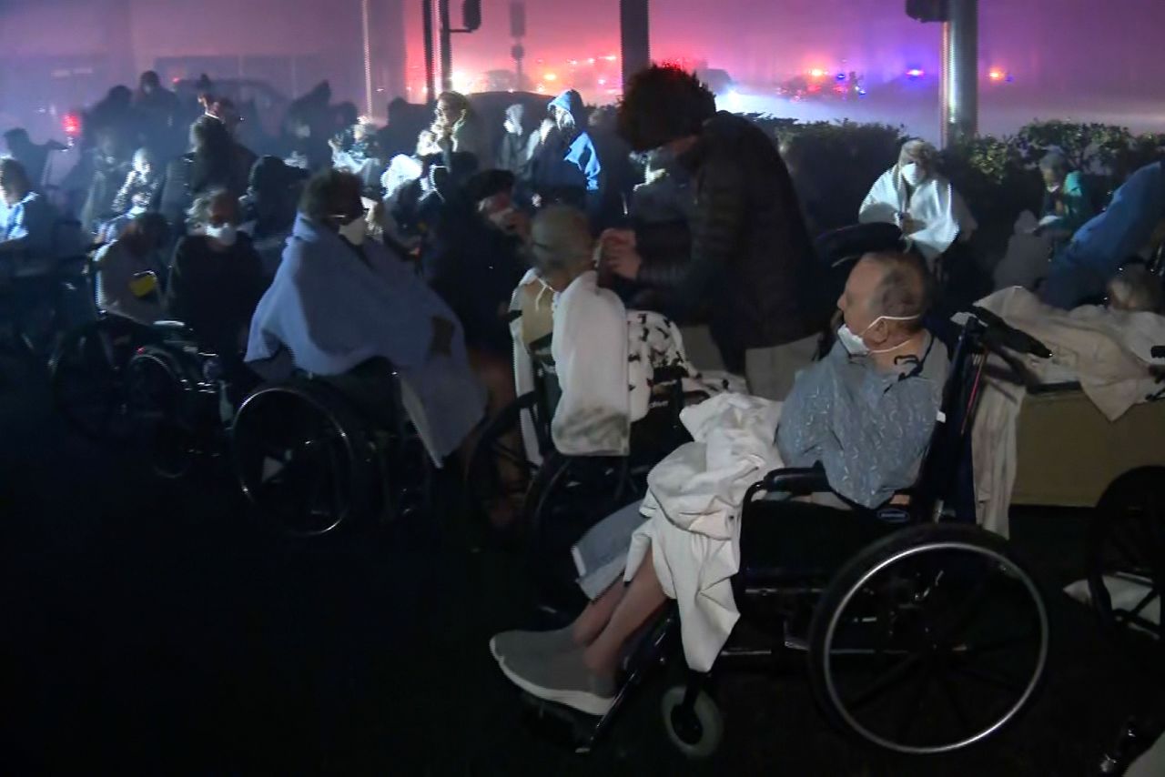 Elderly residents in wheelchairs are evacuated from a Pasadena senior center.